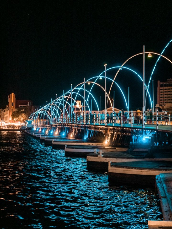 The Queen Emma pontoon bridge in Willemstad glowing with arches of light at night