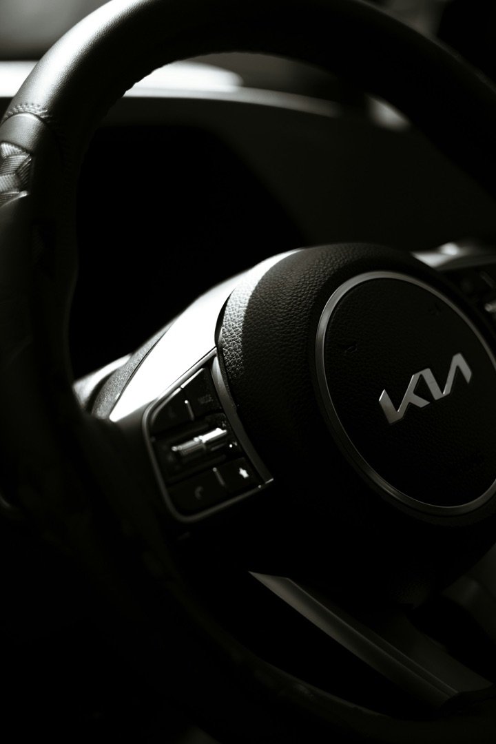 Close-up of a Kia steering wheel in a dark car interior
